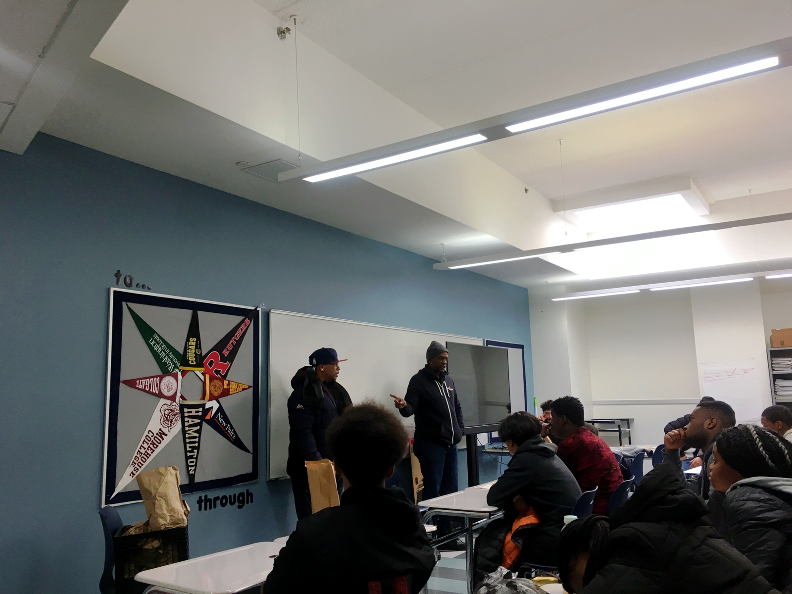 Barry & Coach David speaker standing in front of a classroom leading a youth conversation